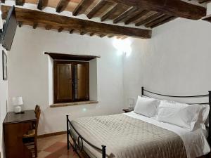 a bedroom with a bed in a room with a window at Agriturismo Le Querciole in Val d'Orcia in Bagno Vignoni