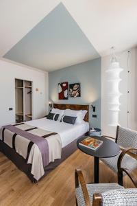 a bedroom with a large bed and a table at Hotel Priori Secret Garden in Perugia