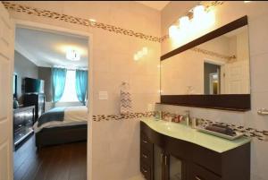 1 dormitorio con 1 cama y baño con lavabo. en The SoMa Furnished Residences en Hamilton