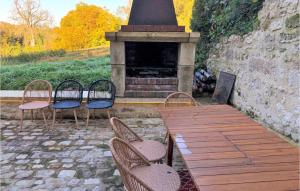 a group of chairs sitting on a wooden deck with a fireplace at Cozy Home In Saint-Cyr-En-Arthies in Saint-Cyr-en-Arthies