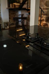 a stove top oven with a candle on a counter at Casa de Campo Gracinda in Tourém