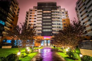 um edifício numa cidade à noite com árvores em Orhideea Residence & Spa em Bucareste