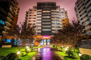 a building in a city at night with trees at Orhideea Residence & Spa in Bucharest