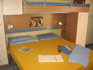 a bedroom with a yellow bed with two bunk beds at Il Gabbiano Blu - Monolocale Giallo in Marettimo