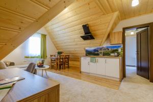 Suchowianka Ski&Relax في بيالكا تاترزانسكا: مطبخ وغرفة معيشة بسقوف خشبية