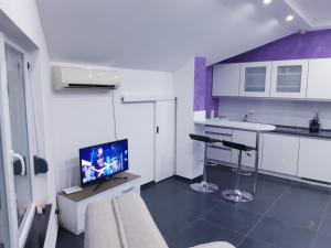 a living room with a tv and a kitchen at apartman Dani in Derventa