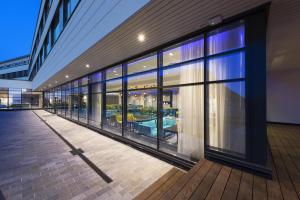 a building with large glass windows and a patio at Thon Hotel Fosnavåg in Fosnavåg