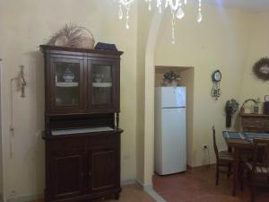 a kitchen with a wooden cabinet and a refrigerator at Scalea Historic Center Apartments in Scalea