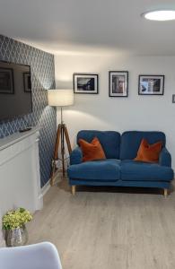 a blue couch in a living room with a tv at Antrim Coast Apartments in Cushendall