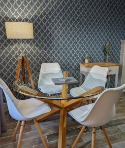 a glass table with white chairs in a room at Antrim Coast Apartments in Cushendall