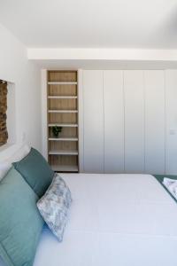 - une chambre avec un grand lit blanc et un oreiller vert dans l'établissement Casa dos Copos - Drinks House, à Miranda do Corvo