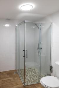 a glass shower in a bathroom with a toilet at Casa dos Copos - Drinks House in Miranda do Corvo +11 photos