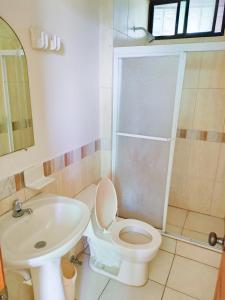 a bathroom with a toilet and a sink at Suites Marbensa, Malecón de Atacames in Atacames