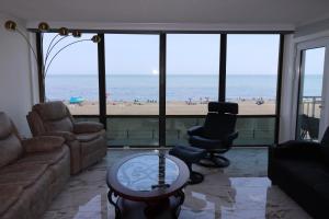 a living room with a view of the beach at Oceanfront beach, sky, & dolphins in Virginia Beach