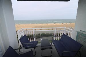 a balcony with chairs and a view of the beach at Oceanfront beach, sky, & dolphins in Virginia Beach