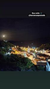 a city lit up at night with a church at Pousada Barrancas in Piranhas