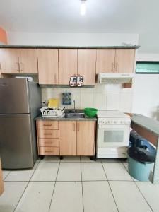 a small kitchen with a sink and a refrigerator at Suites Marbensa, Malecón de Atacames in Atacames