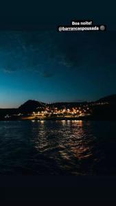 una vista notturna di una città e dell'acqua di Pousada Barrancas a Piranhas