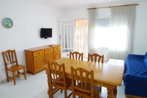 uma sala de jantar com mesa e cadeiras e um sofá azul em TEPINSA · Alquiler de Apartamentos em Torreblanca