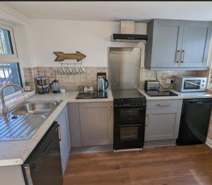 a kitchen with a sink and a stove top oven at Antrim Coast Apartments in Cushendall