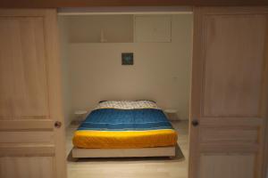 ein kleines Bett in einem kleinen Zimmer mit zwei Türen in der Unterkunft T3 standing 