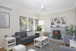 a living room with a couch and a fireplace at Ronelle Cottage in Berrima