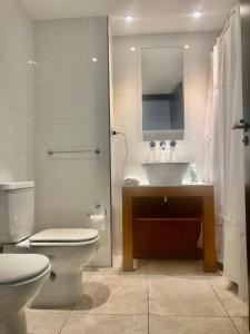 a bathroom with a toilet and a sink and a mirror at Edificio fresh pampa in Buenos Aires