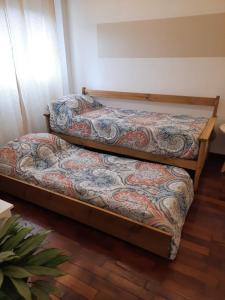 two twin beds in a room with avertisementforgrimgrim at Dpto Andino in Mendoza