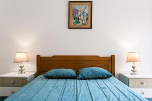 ein Schlafzimmer mit einem blauen Bett und zwei Nachttischen in der Unterkunft Isabel Dream IV in Algueirão-Mem Martins