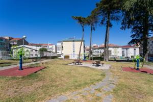 einen Park mit zwei Picknicktischen und einem Spielplatz in der Unterkunft Isabel Dream IV in Algueirão-Mem Martins