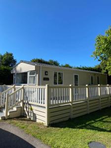 uma casa móvel com uma cerca branca em Delightful Holiday Home at River Valley near Penzance em Penzance