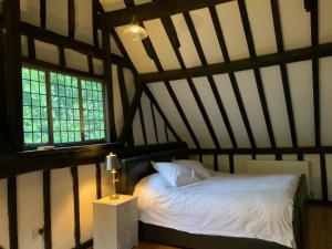 łóżko w pokoju z 2 oknami w obiekcie Delightful 4BD Home full of Flair Edenbridge Kent w mieście Edenbridge
