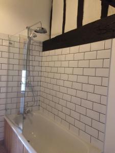 a bathroom with a bath tub with white tiles at Delightful 4BD Home full of Flair Edenbridge Kent in Edenbridge
