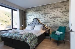 ein Schlafzimmer mit einem Bett und einem grünen Stuhl in der Unterkunft Thon Hotel Fosnavåg in Fosnavåg + 26 Fotos