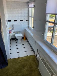 Luc's place, Waterbed grote kamer في Zoeterwoude: حمام مع مرحاض ونافذة