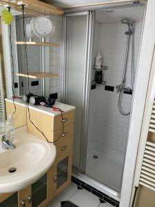 La salle de bains est pourvue d'un lavabo et d'une douche. dans l'établissement Luc's place, Waterbed grote kamer, à Zoeterwoude