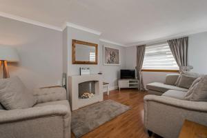 een woonkamer met 2 banken en een open haard bij Centrally Situated 1 Bedroom House in Cumbernauld in Cumbernauld