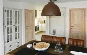 a kitchen with a dining table with chairs and aendant light at Lovely Home In Breegejuliusruh in Juliusruh