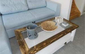 a living room with a blue couch and a table at Lovely Home In Breegejuliusruh in Juliusruh