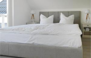 ユリウスルーにあるAwesome Home In Breege-juliusruh With 2 Bedrooms, Sauna And Wifiの白いシーツと枕が備わる大きな白いベッド