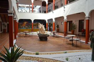 un patio con una estatua en el medio de un edificio en La Casona Pirámides, en San Martín de las Pirámides