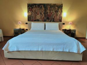 1 dormitorio con 1 cama blanca grande y 2 lámparas en CASA DUCHESSE al Castello, en Ferrara