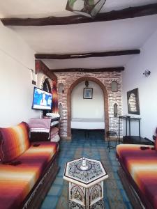 ein Wohnzimmer mit 2 Sofas und einem Tisch in der Unterkunft Dar naya in Chefchaouen