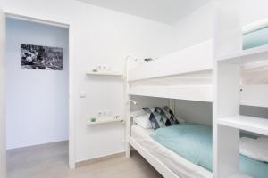 1 dormitorio con literas blancas y 1 cama azul en La Fula Beach Rooms, en El Pris