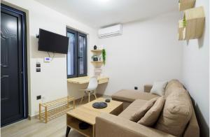 uma sala de estar com um sofá e uma mesa em Neoclassical Apartments with backyard acess em Atenas