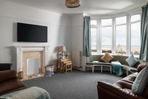 a living room with a couch and a fireplace at Beachcliffe House - Sea front property - Sleeps 10 - Pet friendly in Llandrillo-yn-Rhôs