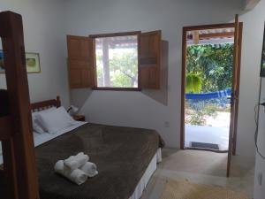 una camera da letto con un letto con due asciugamani sopra di pousada corais de abrolhos a Caravelas