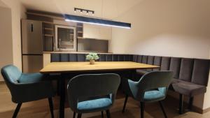 comedor con mesa de madera y sillas en Parenzo Premium Apartment, en Poreč