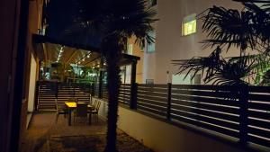 un restaurante con una mesa y una palmera por la noche en Parenzo Premium Apartment, en Poreč
