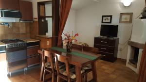 een keuken met een tafel met stoelen en een televisie bij Apartments by the sea Cove Pokrivenik, Hvar - 5224 in Gdinj